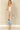 Shop Wall beige open front long sleeve cardigan with side pockets worn by a blonde model with jeans and ankle boots