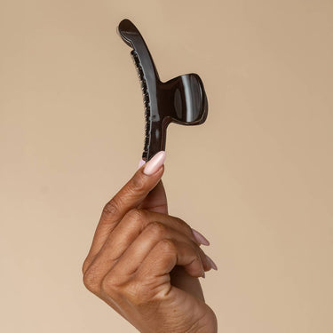Large Arched Clip Black held by a hand against a neutral background, showcasing its eco-friendly design and sleek finish.