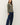 Side view of model wearing sage green raglan sleeve pullover sweater with jeans