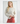 Front view of model wearing Irisha oatmeal diamond pointelle sweater with red pants