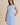 Light blue boat neck sleeveless side tie mini dress worn by a model, front view