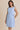 Light blue boat neck sleeveless side tie mini dress worn by a model, front view