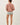 Back view of model wearing pink long sleeve top with denim shorts