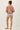Back view of model wearing pink long sleeve top with denim shorts