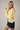 Model wearing yellow Round Rolled Hemline Detail Thin Sweater Cardigan with navy shorts
