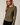 Side view of model wearing olive green Boat Neck Semi Bell Long Sleeve Knit Top with black pants