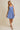 Model wearing SURPLICE S.P.G STRAP FALRE HEM DITSY MINI DRESS in blue floral print.
