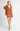 Model wearing Elianna rust wide collar cardigan with white shorts