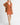 Model wearing Elianna rust wide collar cardigan with white shorts