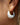 Roselle 18K Gold Non-Tarnish Teardrop Hoop Earrings worn in an ear, showcasing a stylish design.