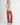 Side view of model wearing Irisha oatmeal diamond pointelle sweater with red pants