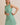 BOAT NECK SLEEVELESS SIDE TIES MINI DRESS model wearing size small in green striped fabric