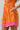 Model showcasing the Donna Dot Elanie Button Down Mini Dress with pockets in vibrant orange pink color.