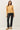 Front view of model wearing yellow button-up cardigan with black pants