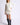Model wearing white Chiara long-sleeve pullover sweater with black pants