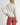 Back view of model wearing Irisha Diamond Pointelle Sweater in Oatmeal, with red pants