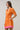 Model wearing the Donna Dot Elanie Button Down Mini Dress in orange pink with pockets and short sleeves.