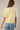 Back view of model wearing yellow short sleeve sweater cardigan