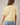 Back view of model wearing yellow short sleeve sweater cardigan