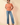 Full-length view of model wearing orange Round Neck Puff Short Sleeve Cable Sweater with blue jeans