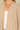 Shop Wall beige open front long sleeve cardigan with a soft knit texture layered over a white top
