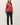 Model wearing red raglan sleeve slub pullover sweater with black pants, full length view