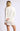 Side view of model wearing white Chiara long-sleeve pullover sweater