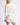Side view of model wearing white Chiara long-sleeve pullover sweater