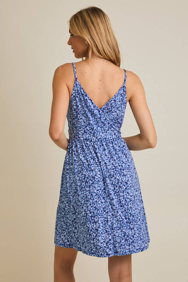 Model wearing SURPLICE S.P.G STRAP FALRE HEM DITSY MINI DRESS from the back, showcasing its floral design.