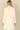 Back view of a woman wearing a Shop Wall cream long sleeve open front cardigan with a smooth knit texture