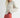 Side view of model wearing Irisha Diamond Pointelle Sweater in Oatmeal, with red pants