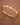 18K Gold PVD Plated Waterproof Stainless Steel Bangle displayed in a curved view on a brown background