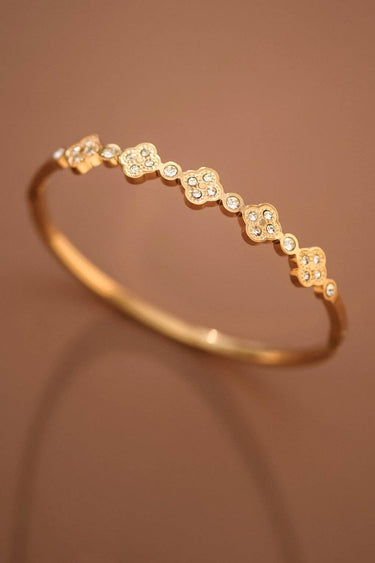 18K Gold PVD Plated Waterproof Stainless Steel Bangle displayed in a curved view on a brown background