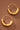 18K Gold Plated Waterproof Stainless Steel Hoop Earrings 7770 displayed against a dark brown background