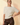 Front view of model wearing cream ribbed knit top with brown pants