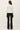 Back view of model wearing white long sleeve top with black pants
