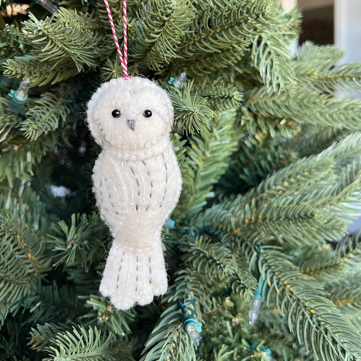 Snowy Owl Felt Wool Christmas Ornament displayed on greenery
