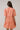 Woman wearing Dixie Split Neck Shift Dress Drift Floral in org pinks multi from the back, showcasing short sleeves and tiered skirt.
