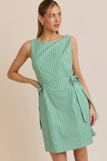Model wearing a BOAT NECK SLEEVELESS SIDE TIES MINI DRESS in green and white stripes.