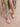 The Andrea Natural Bow Raffia Slide Feminine Summer Flat worn with a polka dot dress, showcasing a stylish summer look.