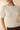 Close-up view of model wearing cream ribbed knit top