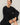Model wearing black short sleeve top while sitting