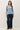 Full-length view of model wearing blue raglan sleeve pullover sweater with jeans