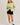 Full-length view of model wearing green short sleeve sweater cardigan with black shorts
