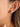 Lush 18K Gold Non-Tarnish CZ Pave Huggie Earrings worn on a model's ear, showcasing the cubic zirconia detail.