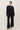 Full-length view of model wearing black short sleeve top with black pants