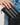 Jocelyn Wallet Tan Card Holder being placed in a stylish black handbag, showcasing its woven texture and elegance.