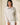Shop Wall beige melange knit pullover with a funnel neckline and half-zip closure worn by a model