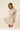 Shop Wall beige striped mini dress with notch neck, short sleeves, button-up detail, and smocked waist on a model.