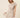 Shop Wall beige striped mini dress with notch neck, short sleeves, button-up detail, and smocked waist on a model.